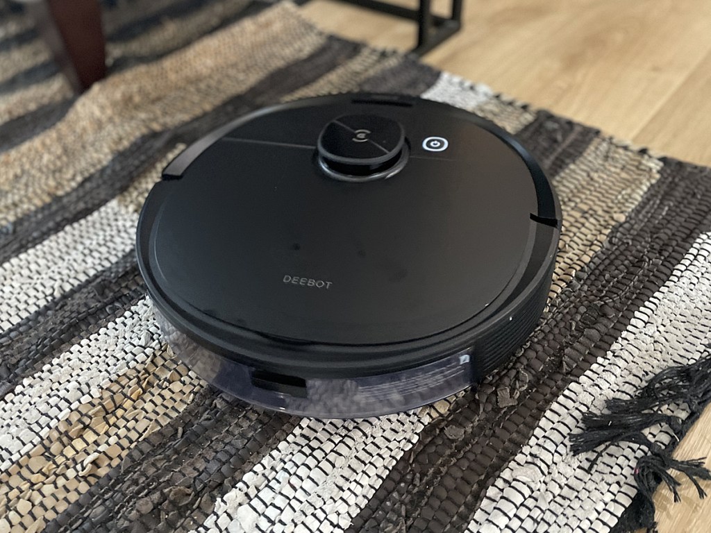 black robotic vacuum cleaner on rug