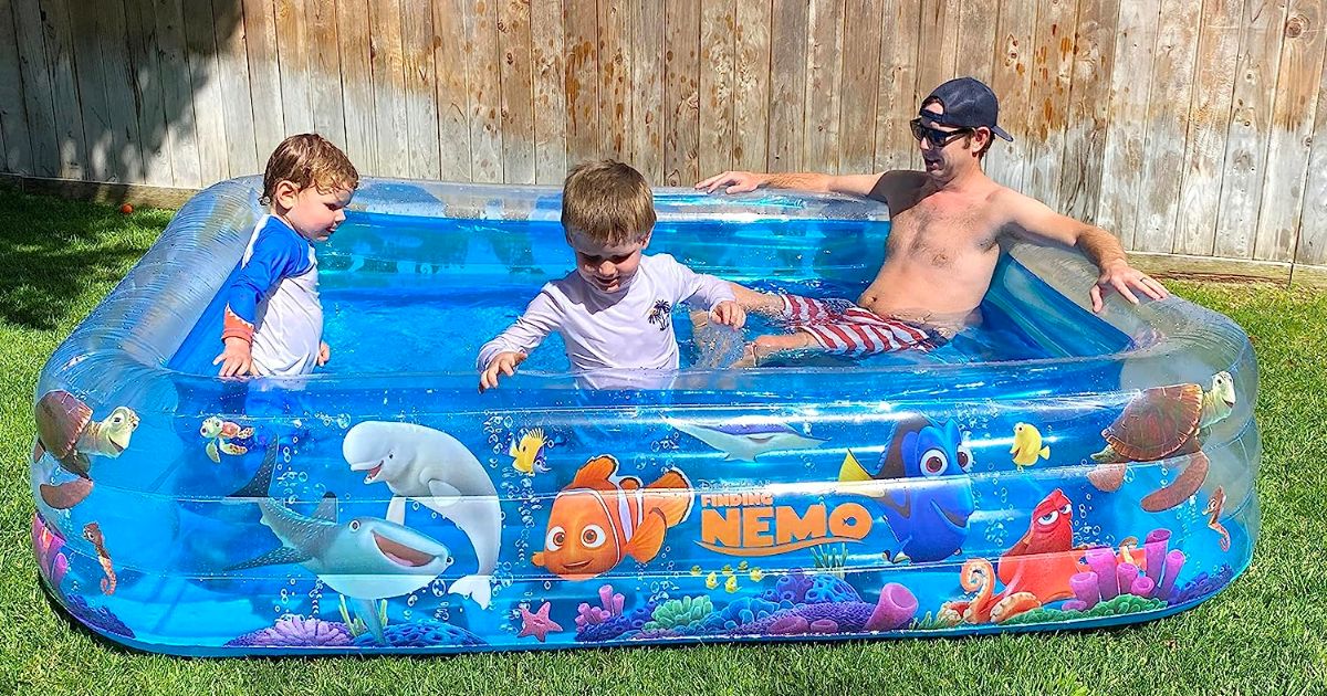 a dad and two little boys playing in a Disney Pixar 6 ft x 8 ft Inflatable Pools neemo