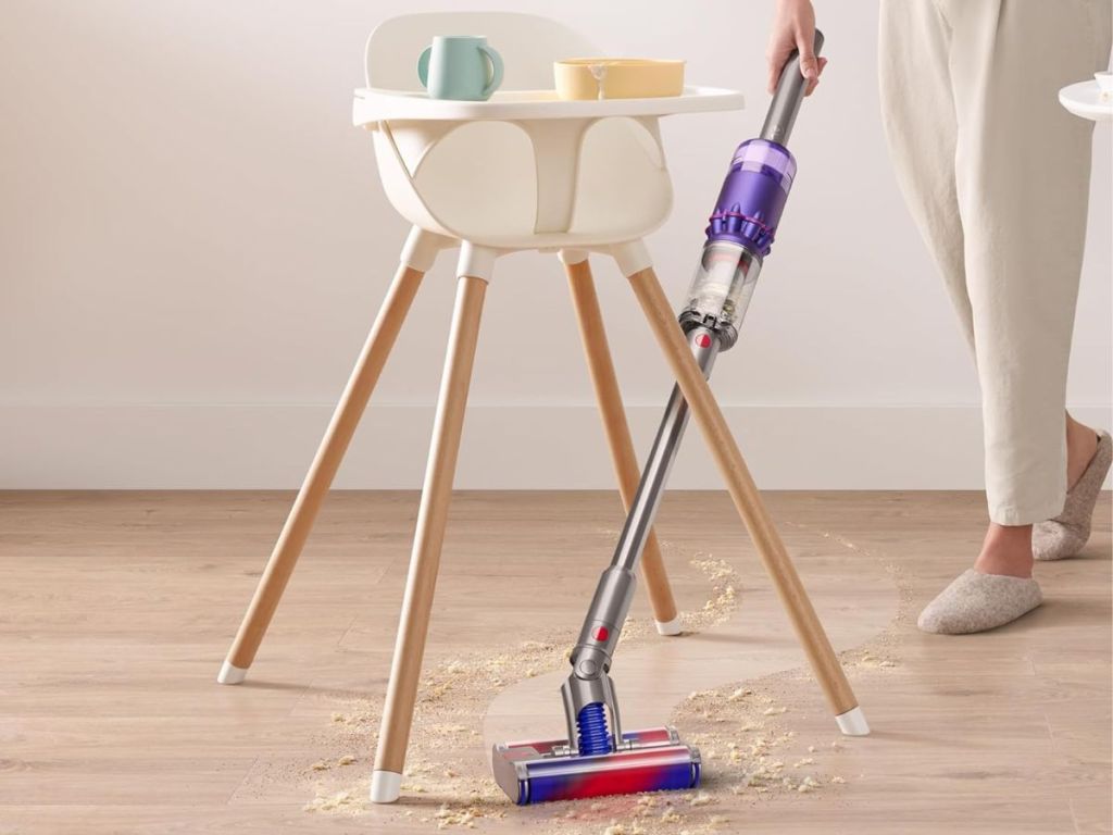 Woman using the Dyson Omni-Flex under a high chair