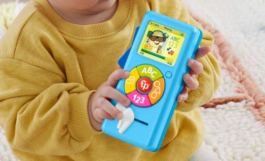 a toddlers hands holding a pretend streaming toy