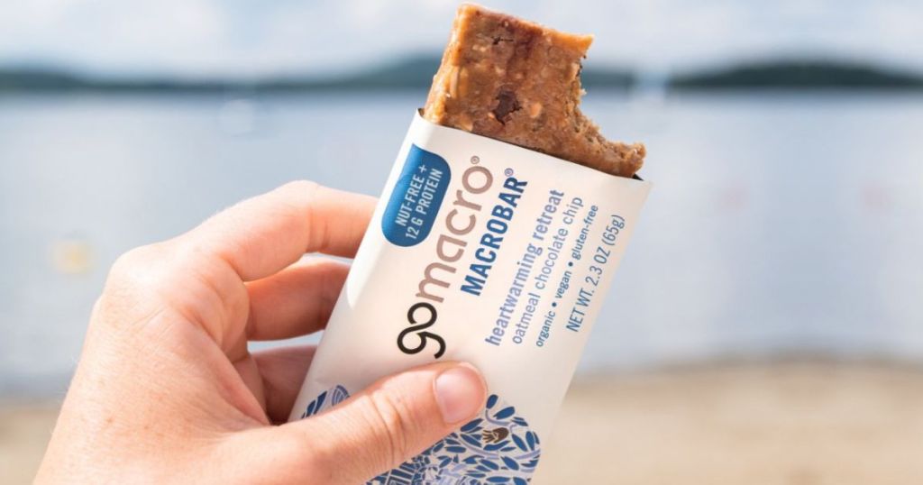 Hand holding a GoMacro bar at the beach