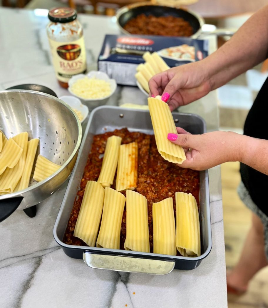 woman stuffing cheese manicotti 