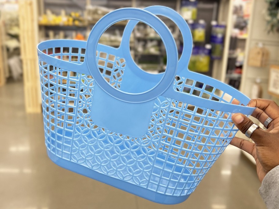 hand holding up a blue jelly tote with large circular handles