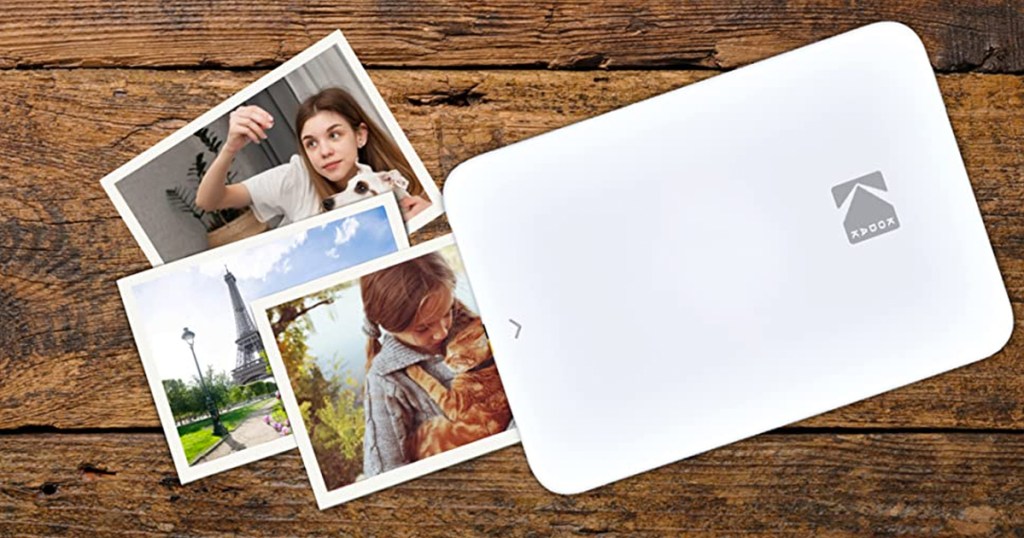 small white photo printer printing out photos on wood table