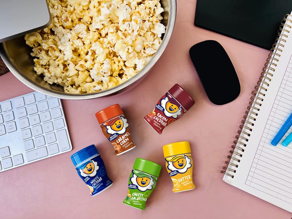 Kernel Season's Popcorn Seasoning on a desk next to a bowl of popcorn