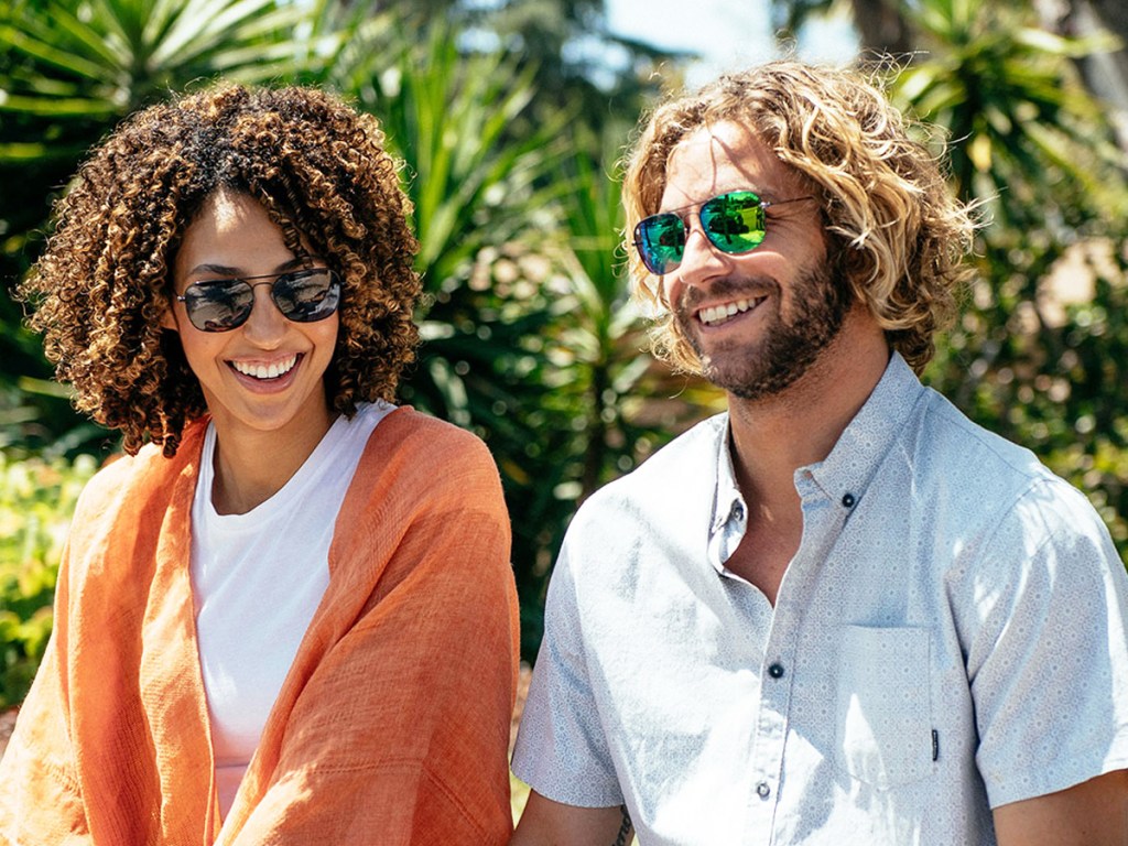 woman and man sitting outside wearing sunglasses