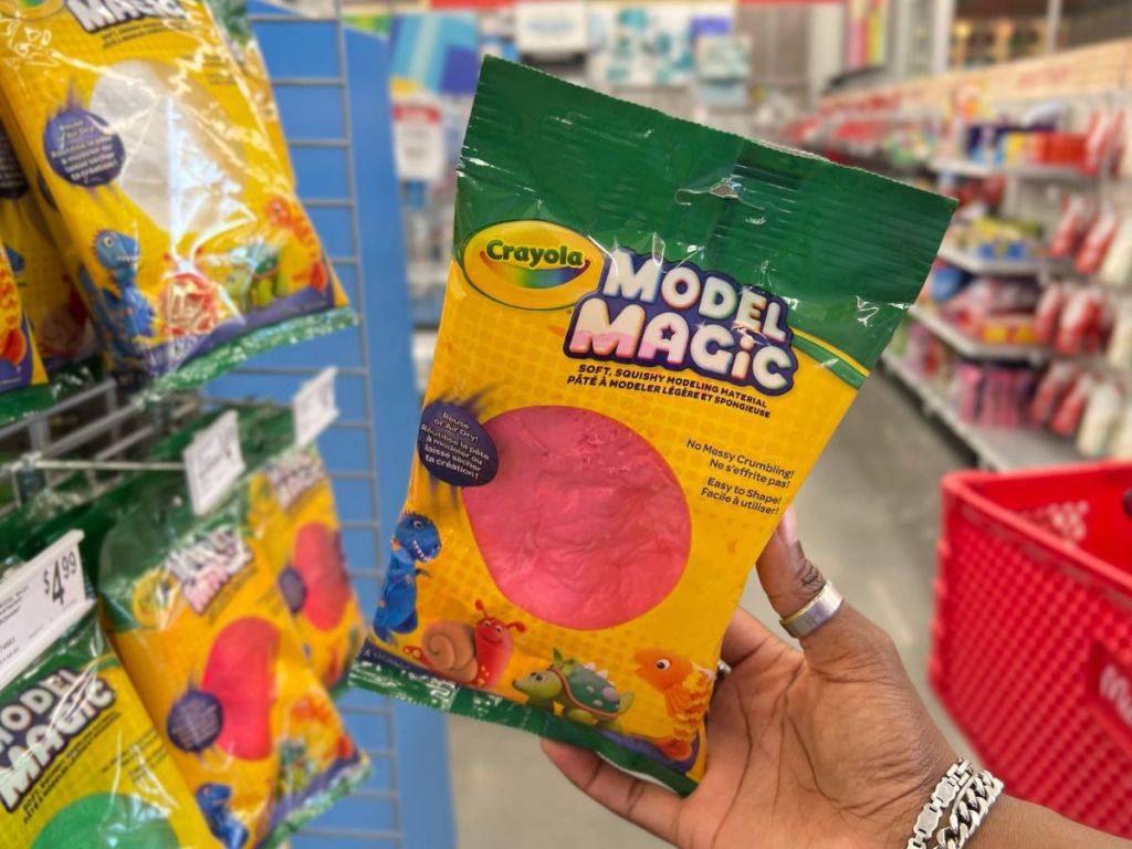 A hand holding crayola pink model magic clay