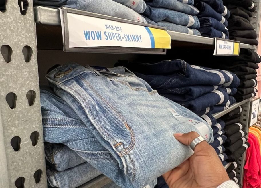 Hand pulling a pair of Old Navy Girls Jeans from shelves