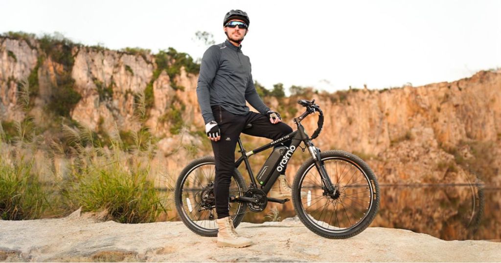 man wearing gray jacket and black pants on bike