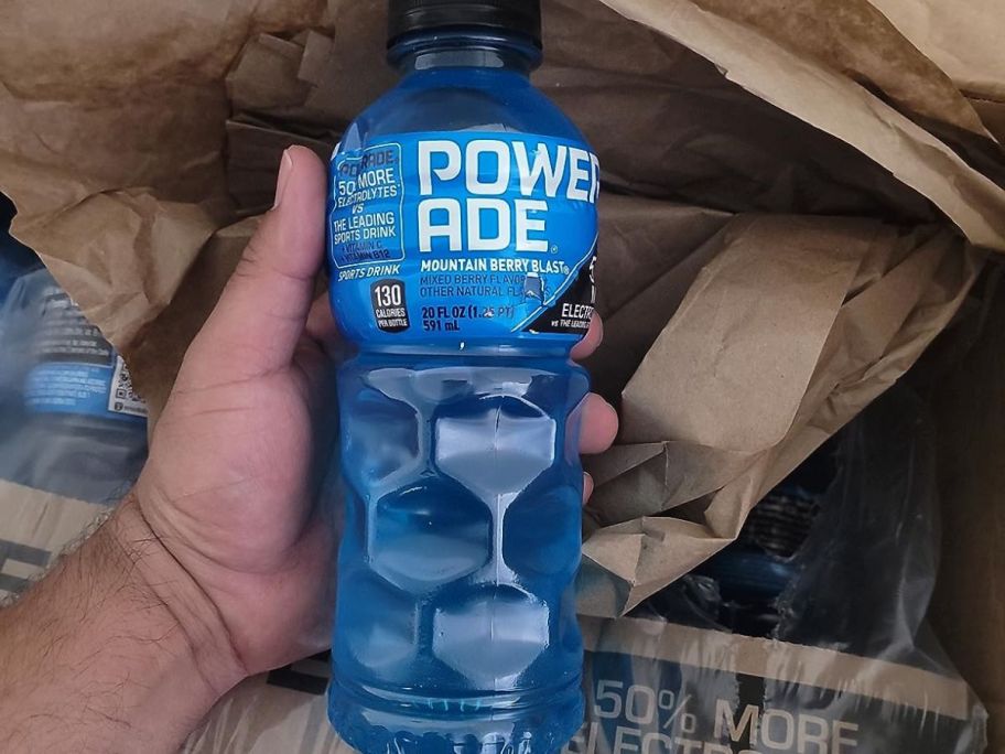 Powerade Mountain Berry Blast in hand above box