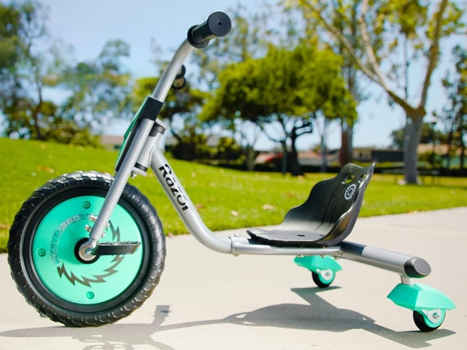 a teal, black, and grey Razor RipRider 360 Mini tricycle sitting outside