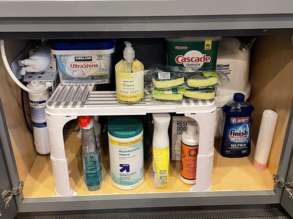 cleaning products on a white organizer in cabinet under kitchen sink