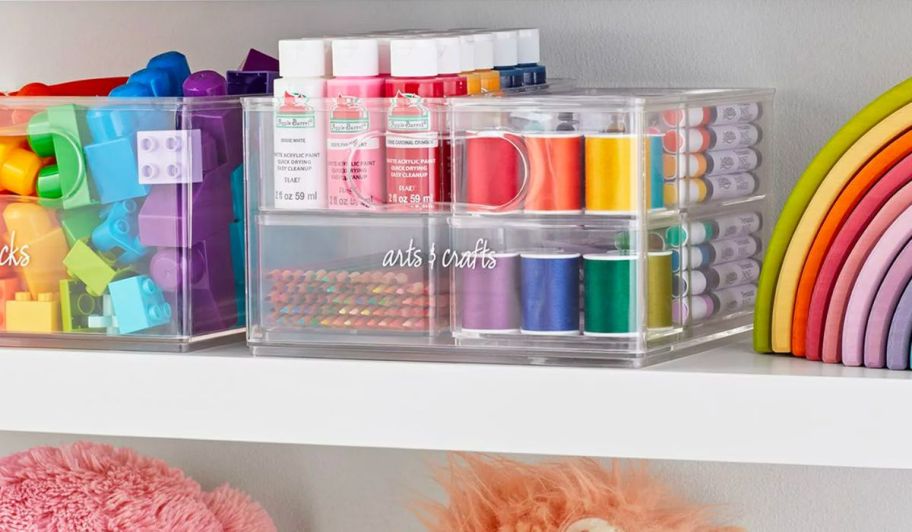 sets of clear storage bins filled with colorful craft and art supplies and legos