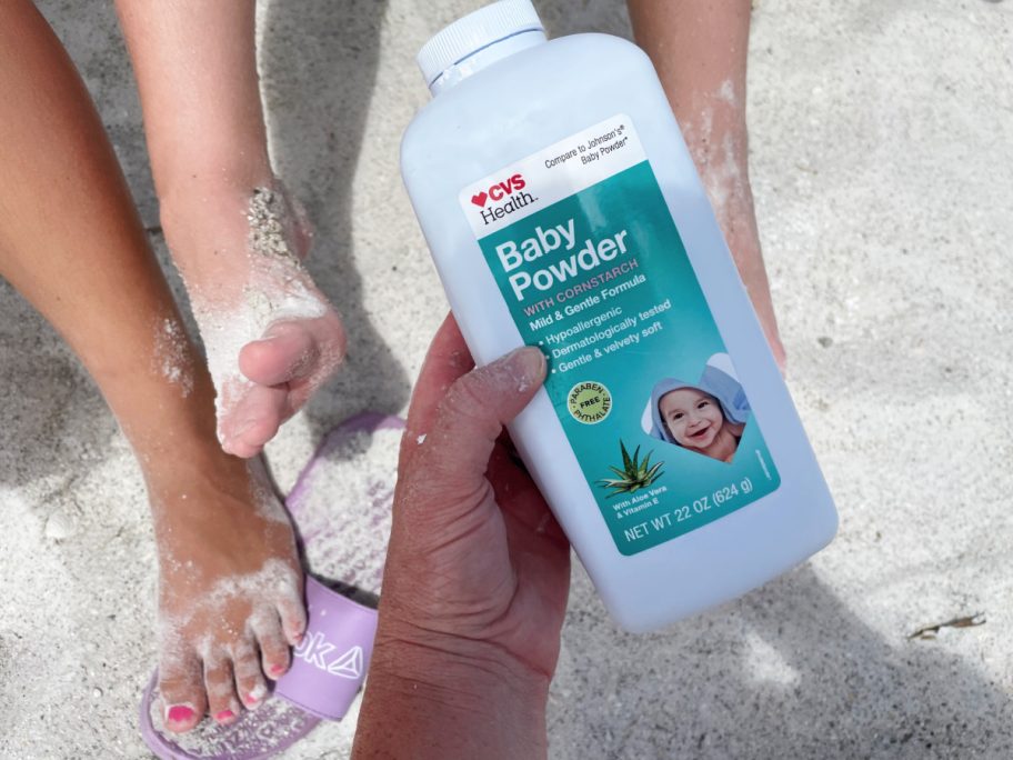 Woman putting baby powder on her children to keep off sand thanks to a clever beach hacks article she read