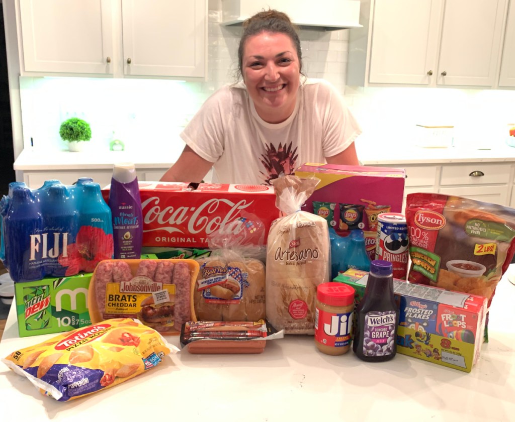 A woman at am AirBNB standing next to her Walmart plus grocery delivery order