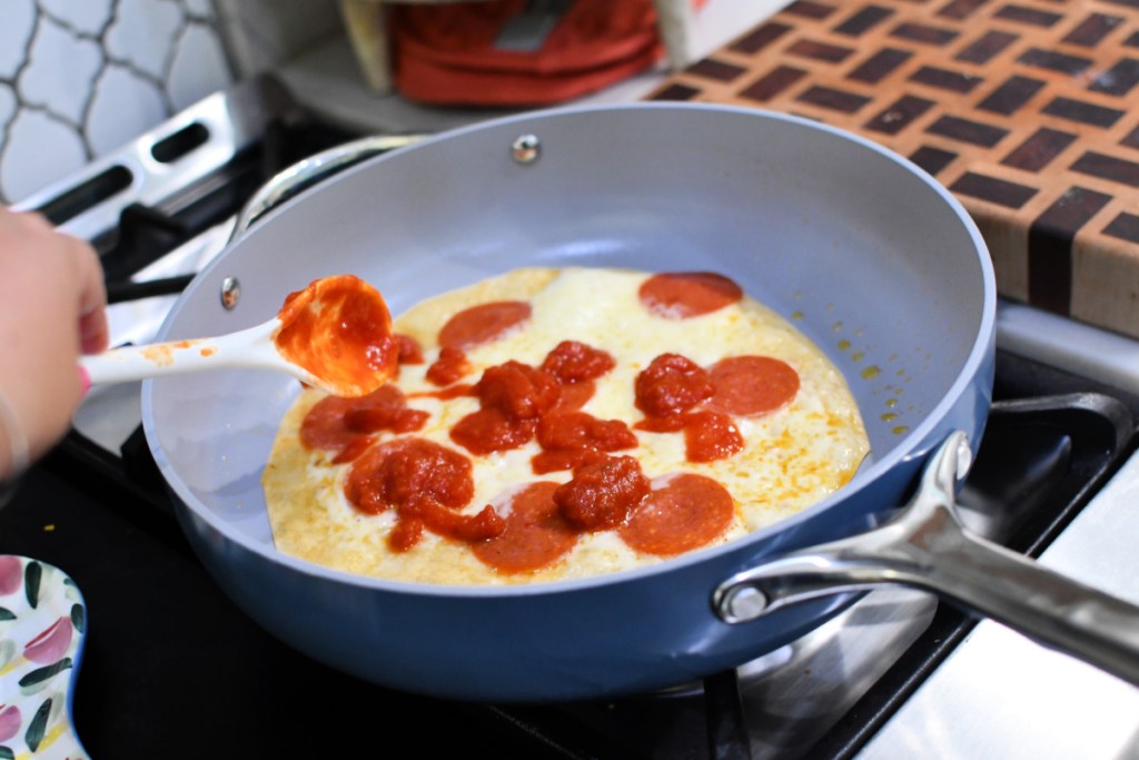 adding marinara to pizza cheesy roll-up