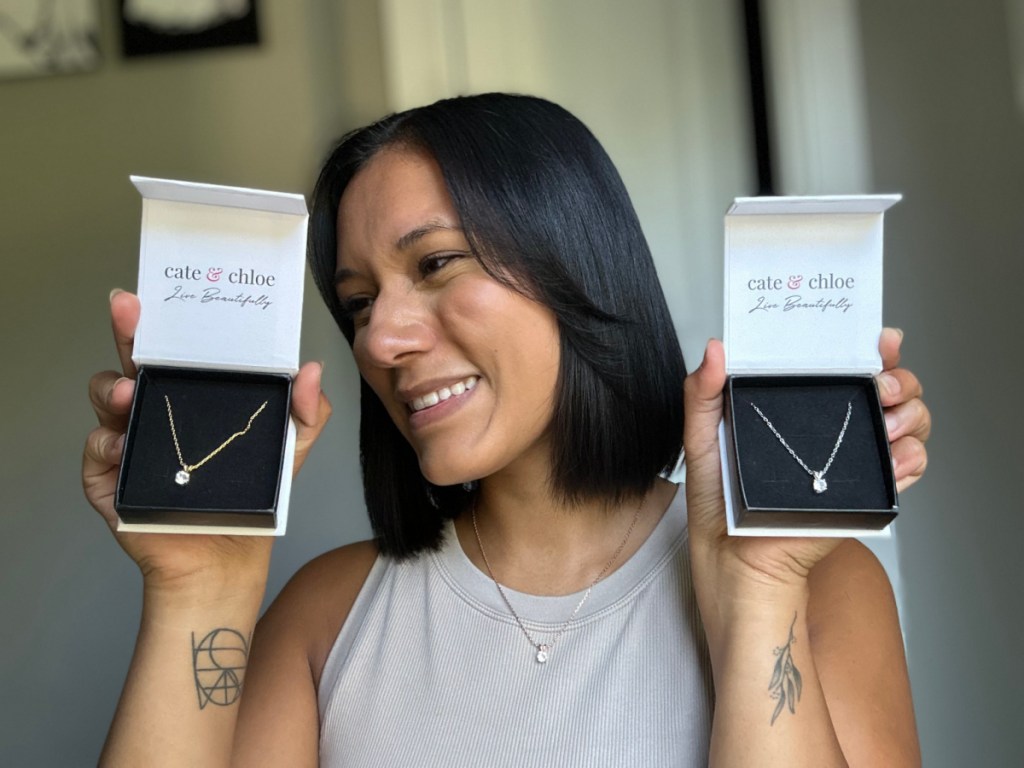 woman holding two necklace boxes