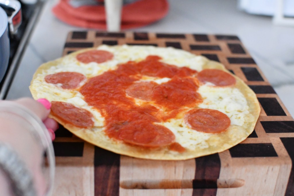 cutting board with melted cheese pizza quesadilla