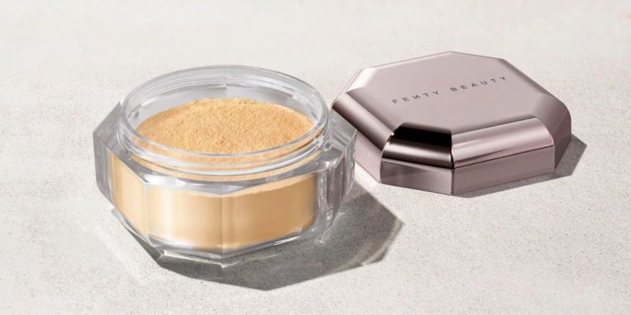 fenty setting powder with lid off on brown surface