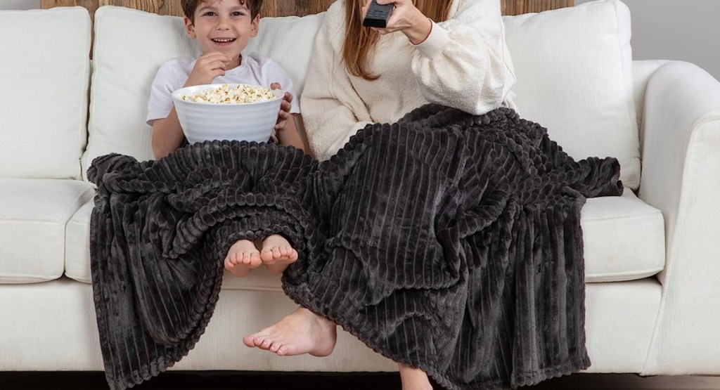 kid and mom using GO Fleece Throw Blanket on the couch