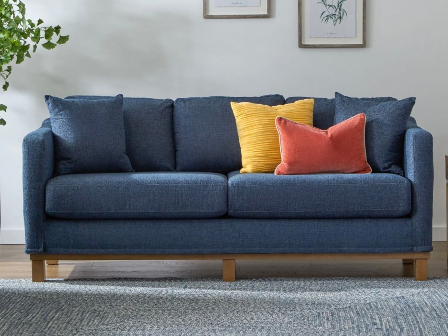 dark blue sofa in livign room with yellow and red pillows