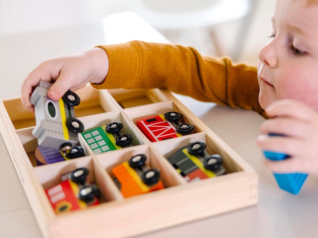 boy playing with 8 piece wooden train set toy