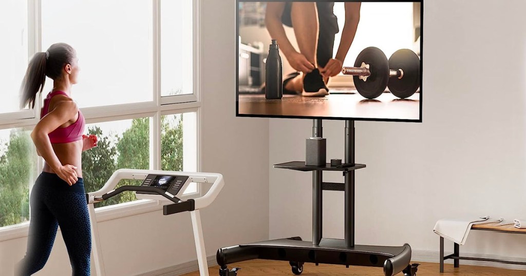 woman running on treadmill with with rolling cart with tv on it