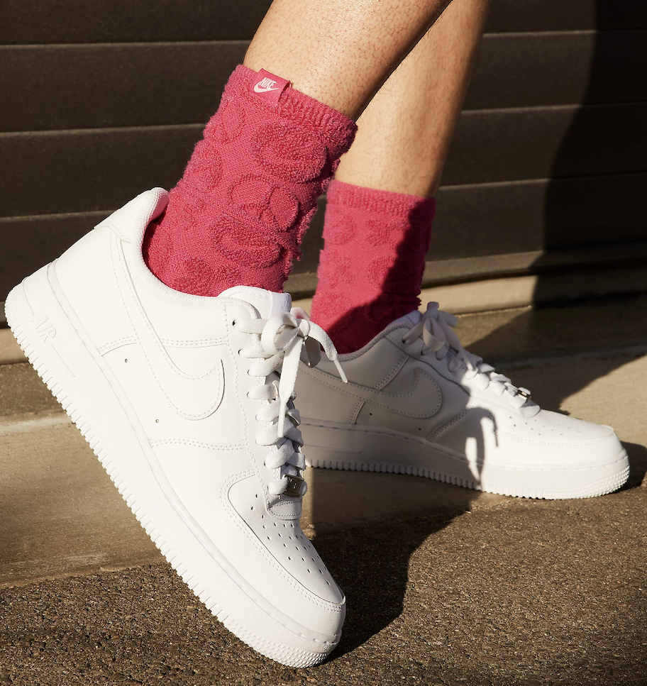 close up of feet wearing nike air force 1's with red peace sign socks