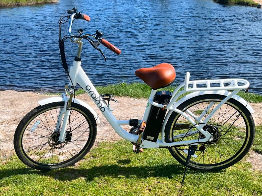 white oraimo electric bike next to pond