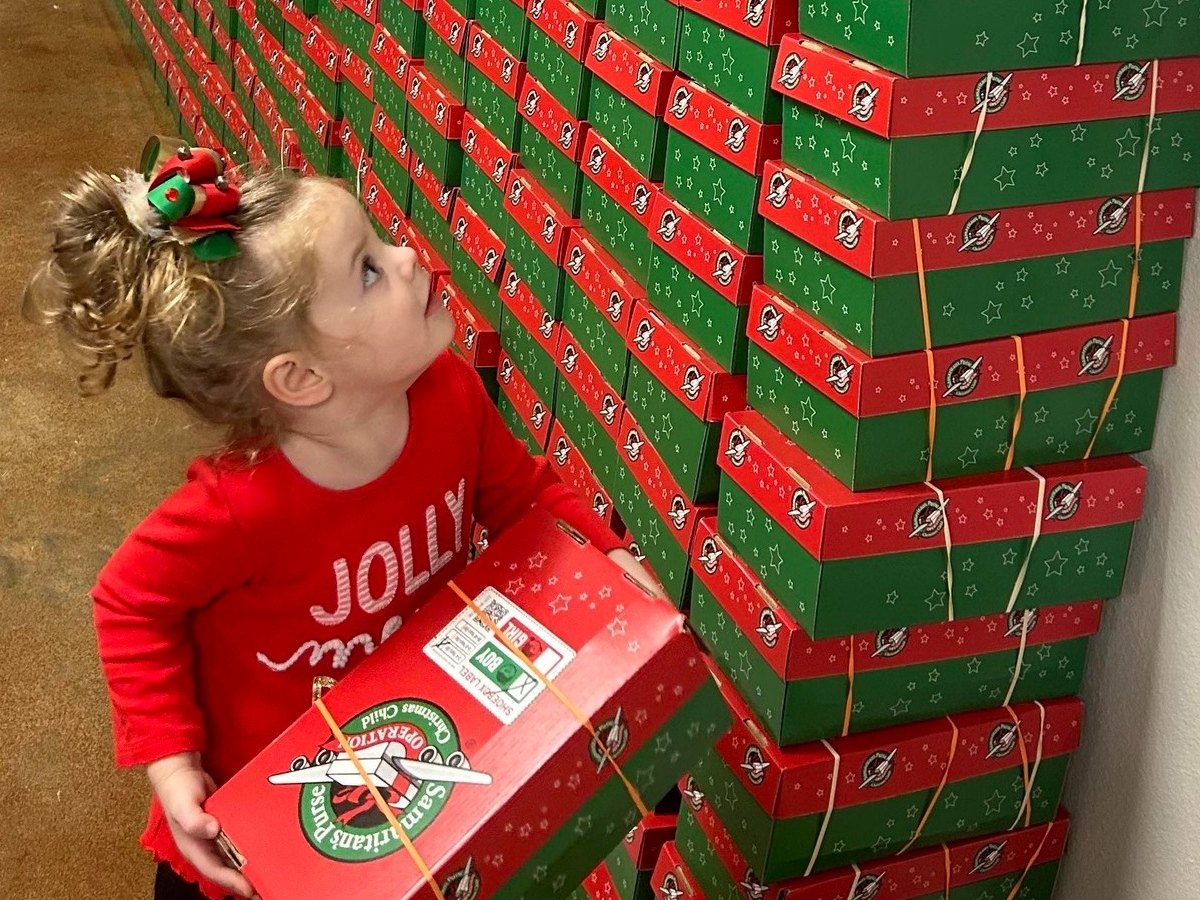 girl stacking Christmas presents