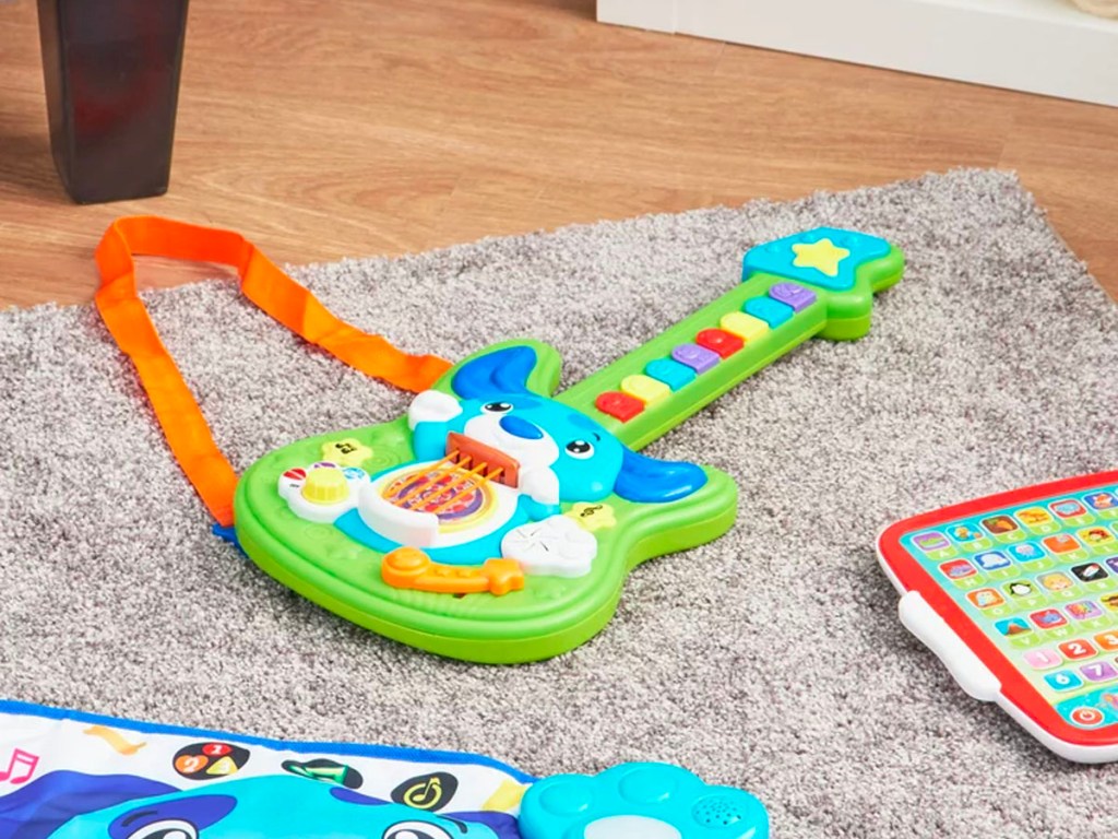 green and blue puppy guitar on floor in room 