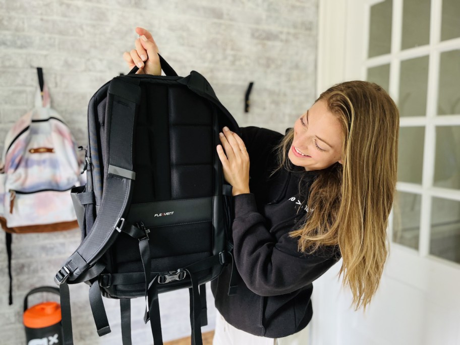 woman holding black bathing bookbag