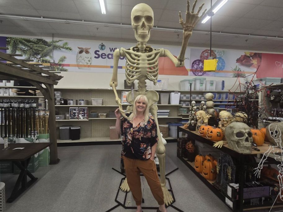 woman standing in front of 10' Posable Skeleton w/ LED in store