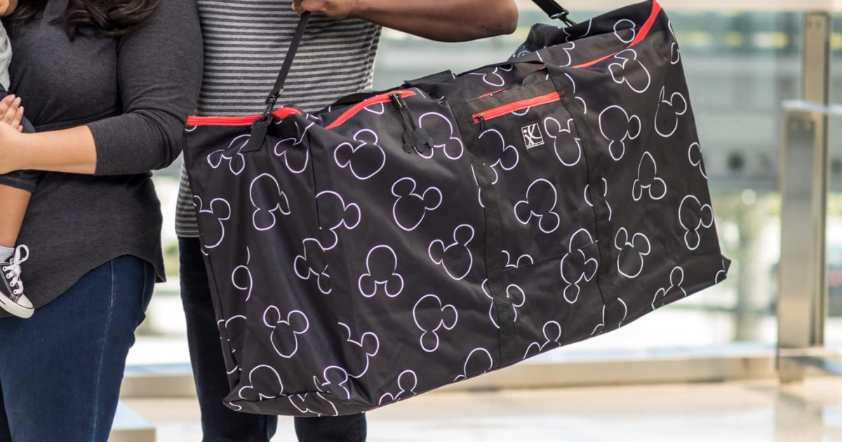 family holding Disney stroller bag as they walk through the airport