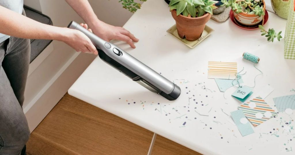 Shark WandVac Cord-Free Handheld Vacuum being used to vacuum up craft cuttings