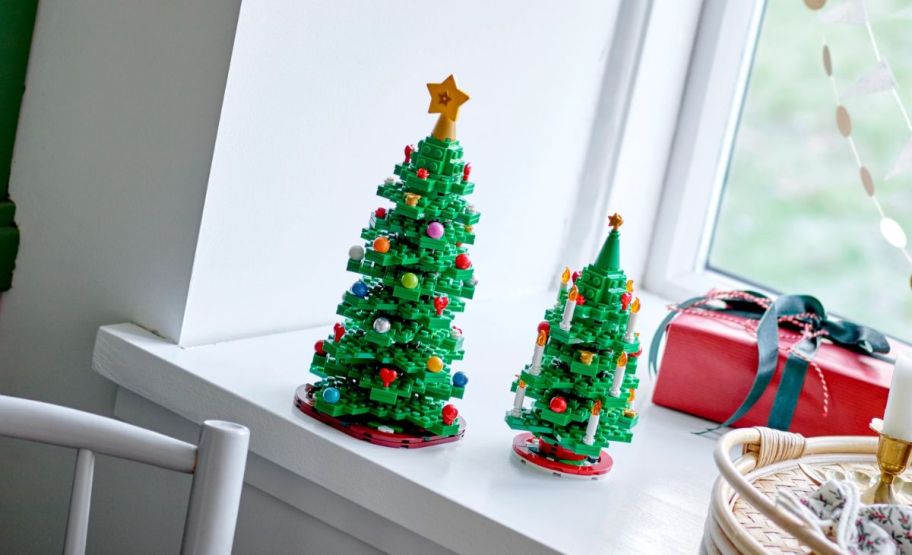 two LEGO Christmas trees on a window ledge