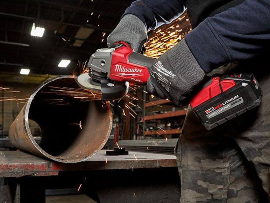 Man using a Milwaukee M18 FUEL 18V Lithium-Ion Brushless Cordless Grinder w/ Paddle Switch on a metal pipe