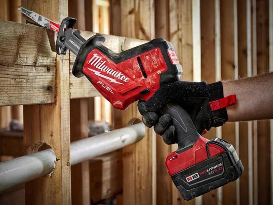 hand using a Milwaukee M18 FUEL 18V Lithium-Ion Brushless Cordless Hackzall Reciprocating Saw on the frame of a house