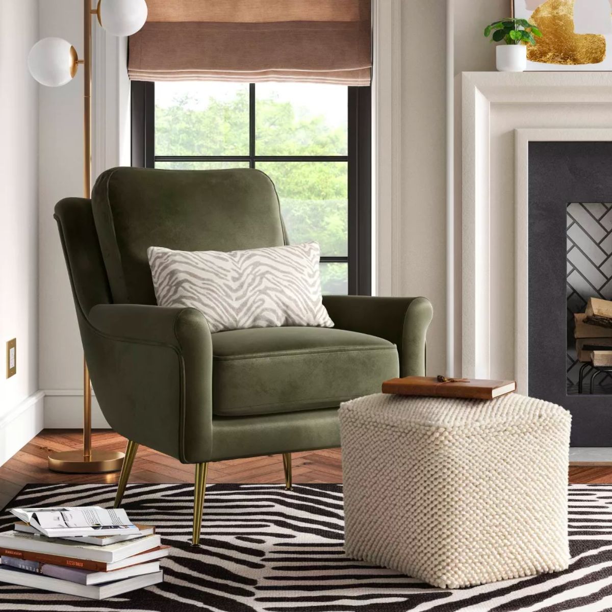 Threshold Lucine Pouf with Removable Fill in Cream in front of a green velvet accent chair