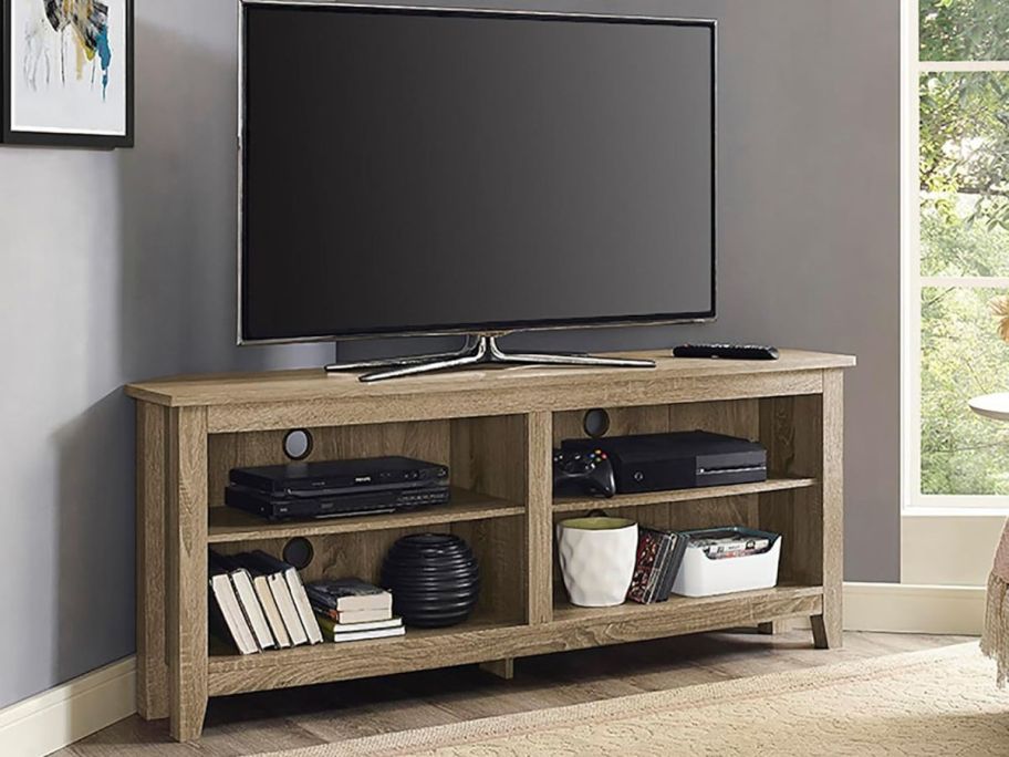 a light wood 2-Shelf Corner TV Stand with tv on top