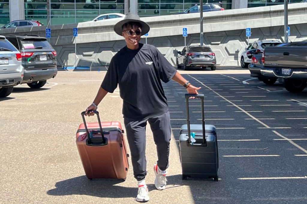 woman with luggage in airport parking lot