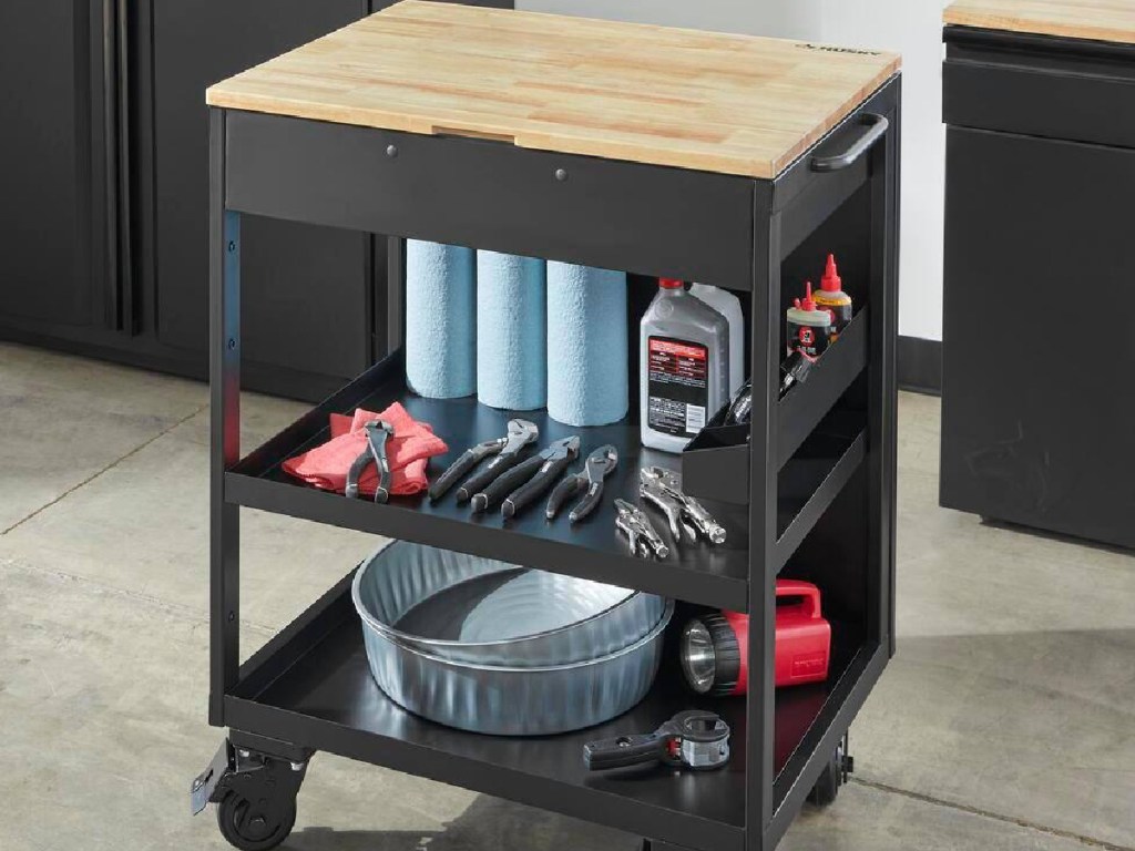 black utility cart with tools on it displayed in a garage