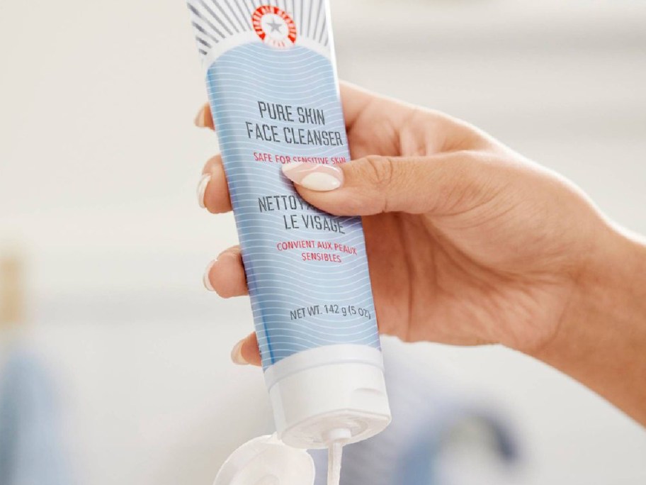 hand squeezing First Aid Beauty Pure Skin Face Cleanser on to palm