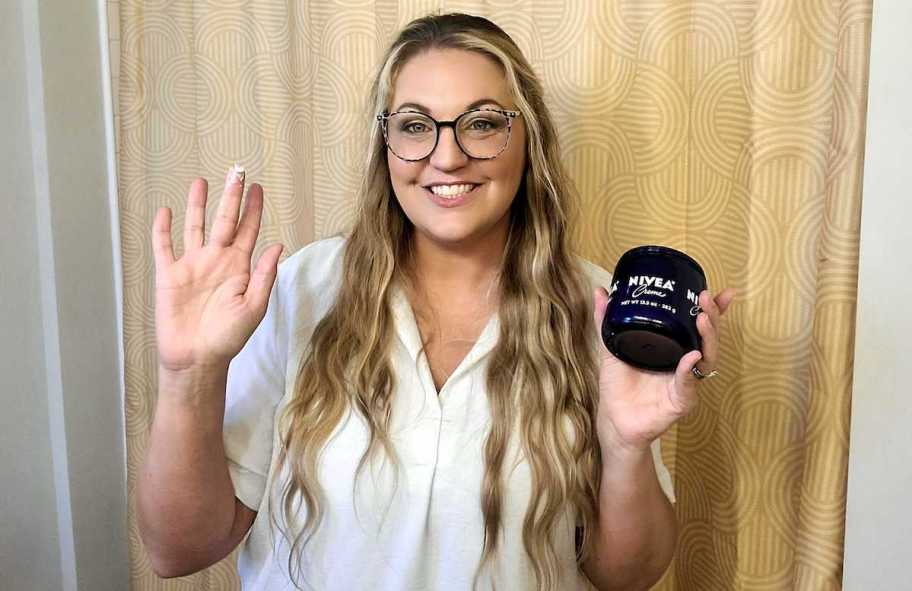 woman holding jar of nivea creme in front of yellow bathroom shower curtain