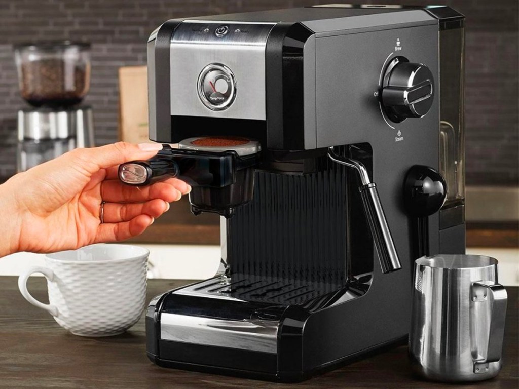 hand taking coffee out of coffee maker