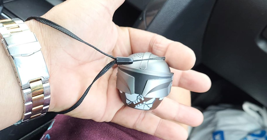 hand holding a silver Mandalorian bluetooth speaker