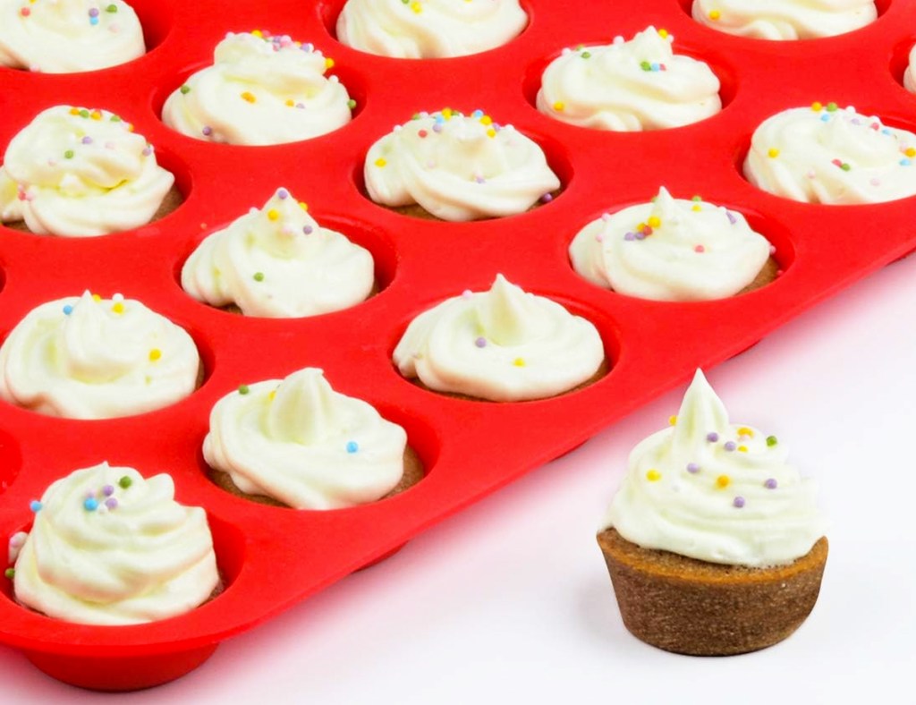 mini cupcake next to a red silicone mini cupcake pan