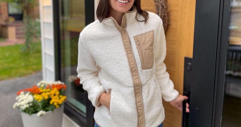 woman outside of front door with fall mums behind her wearing a 32 Degrees Sherpa Jacket