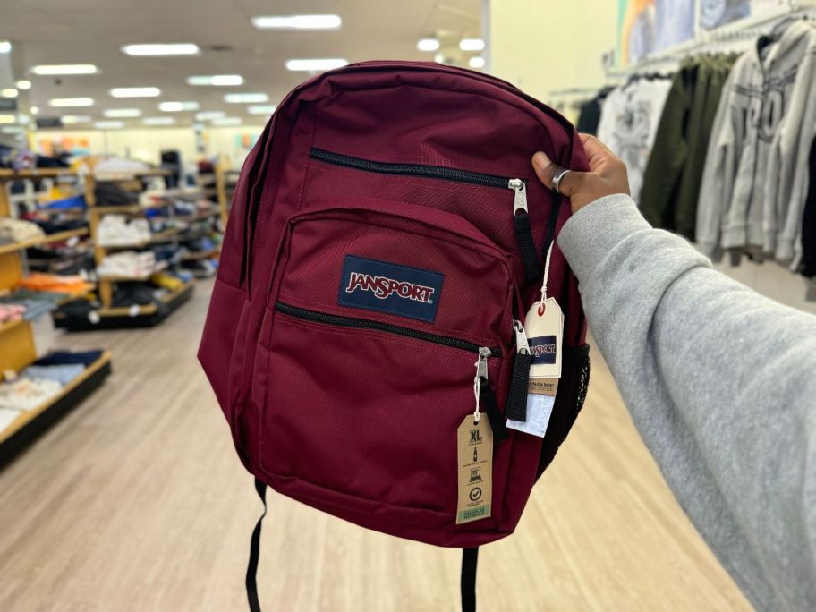 JanSport Big Student Backpack in Russet Red in hand in store