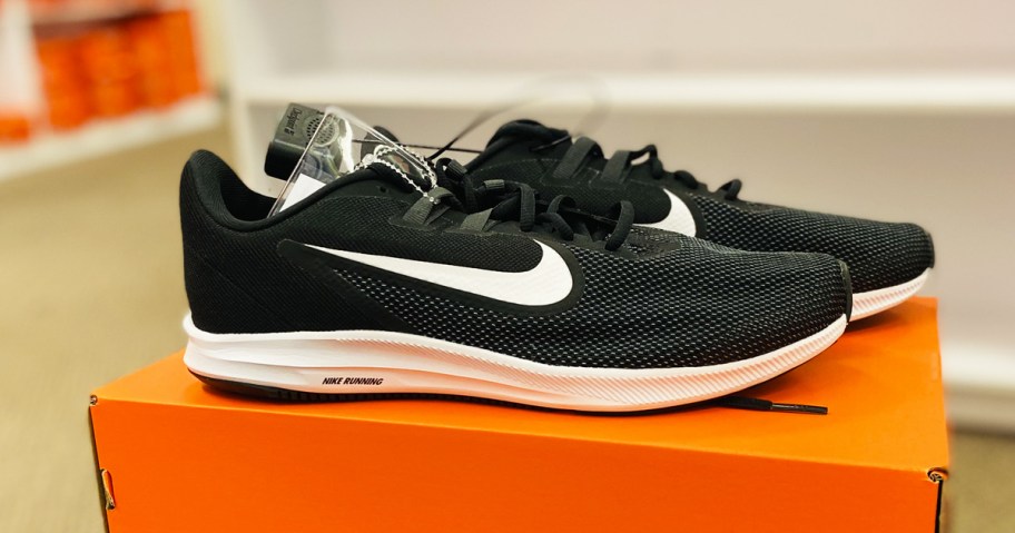 pair of black and white nike running shoes on orange shoe box